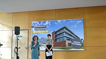 Professorin Katharina Kilian-Yasin, stellvertretende WIID-Studiengangleiterin, (links) und Diplomdesignerin Stephanie Türck (rechts) begrüßen zur Ausstellung auf dem Campus der Fakultät für Technik.