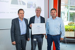 Rektor Prof. Dr. Ulrich Jautz (links) sowie Prof. Dr. Ingolf Müller (rechts), Dekan der Fakultät für Technik, gratulieren Prof. Dr. Karlheinz Blankenbach zur ersten Seniorprofessur an der Hochschule Pforzheim und lächeln in die Kamera