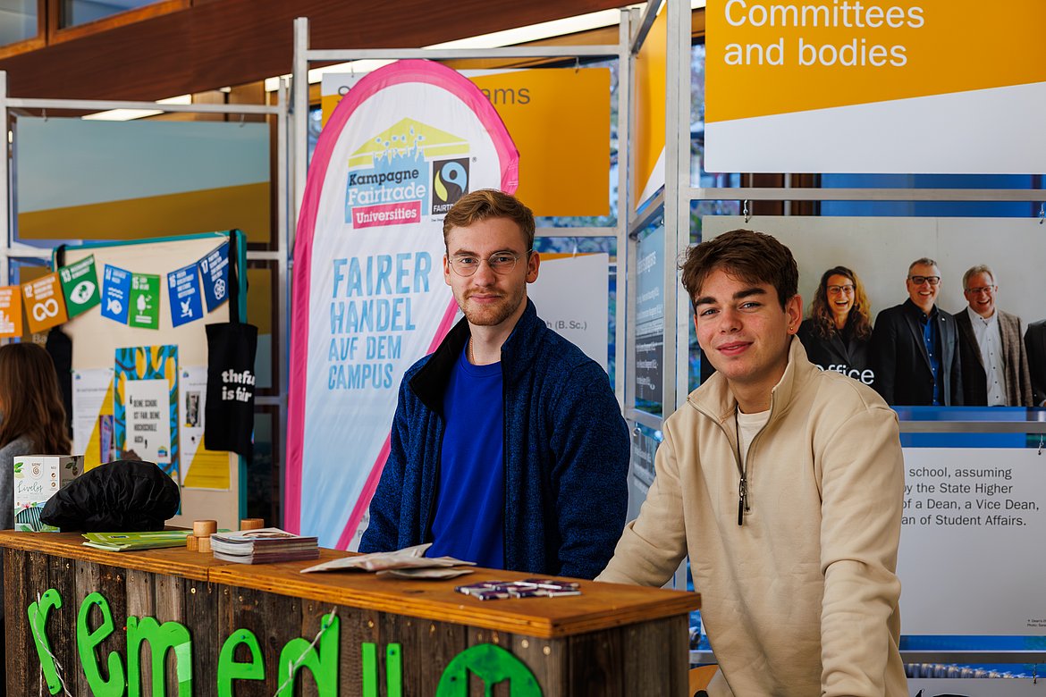 Zwei junge Männer vor einem Fairtrade Banner