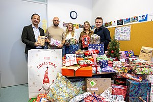 Menschen bei der Spendenübergabe der Hochschule Pforzheim für Pro familia, lächeln in die Kamera.