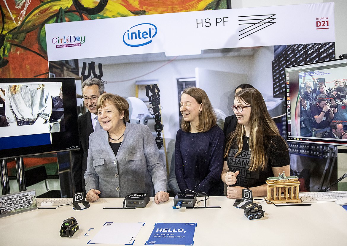 Freuen sich über das Technikprojekt der Hochschule Pforzheim: Angela Merkel und Berliner Schülerinnen lernen im Bundeskanzleramt den Pforzheimer KI-Roboter Vector kennen. (Quelle: InitiativeD21/Corporate Inspiration)